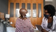 A woman chats with a clinician in her home