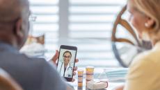 A couple talking to a provider through a video chat on a smartphone.