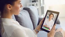 A person talking to a provider via a video chat on a tablet.