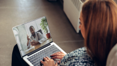 A person talking to a provider through a video chat on a laptop